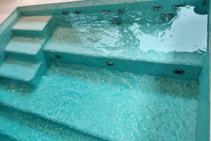 Bigger view of Binnenzwembad met mozaïek betegeling en massage zitbank